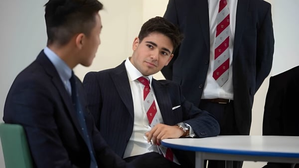 Zwei Männer in formeller Kleidung führen ein berufliches Gespräch in einem Büro auf dem Campus der Warwick School.