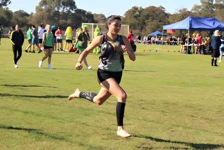 Ein Schüler der Warwick Senior High School läuft auf einem Grasfeld bei einem Sportwettkampf im Freien.