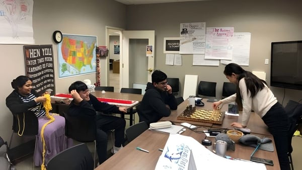 Eine Gruppe von Schülerinnen und Schülern arbeitet gemeinsam an einem Tisch im Studienraum der Washington Preparatory School.