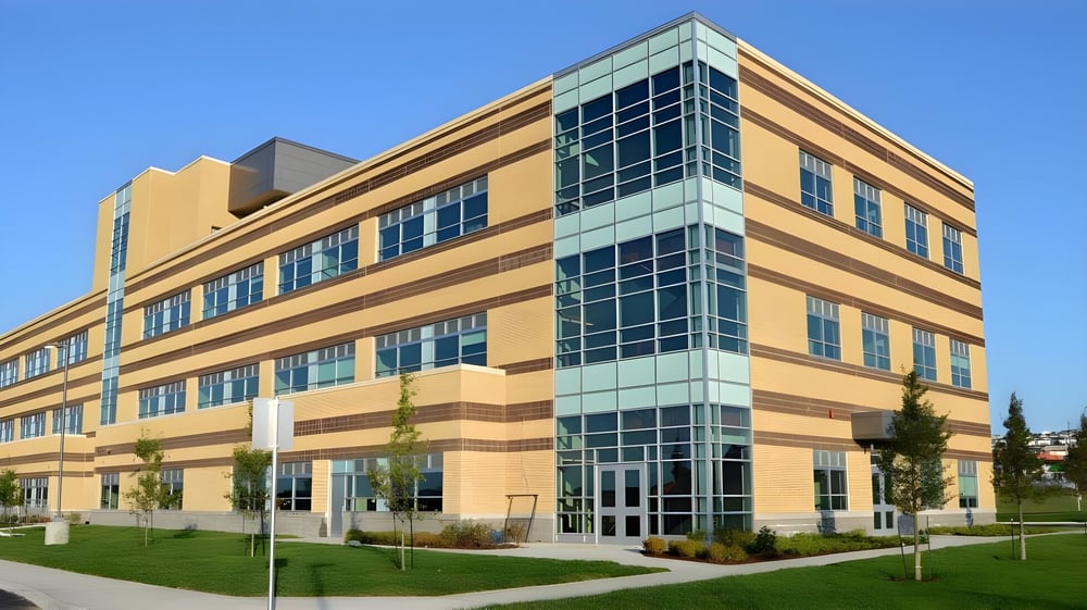 Das moderne mehrstöckige Gebäude der Waterford Valley High School ist von Wiesen und Bäumen umgeben.