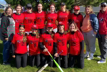 Eine Gruppe junger Fußballspielerinnen in roten Trikots steht auf dem Rasen der Waterford Valley High School.