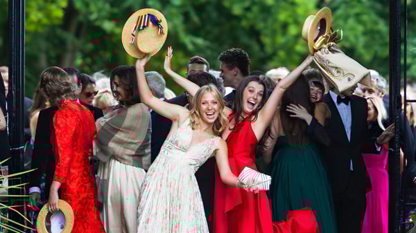 Eine Gruppe von Schülerinnen und Schülern des Wellington College feiert gemeinsam auf dem Schulgelände vor grüner Kulisse.