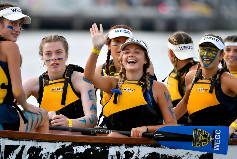Schülerinnen des Wellington East Girls’ College jubeln in gelben Uniformen während einer Veranstaltung.