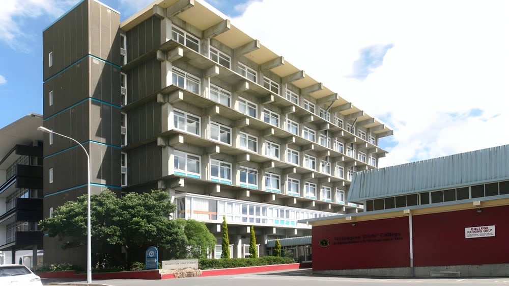 Das mehrstöckige Gebäude mit modernem Design auf dem Campus des Wellington Girls' College ist von Bäumen umgeben.