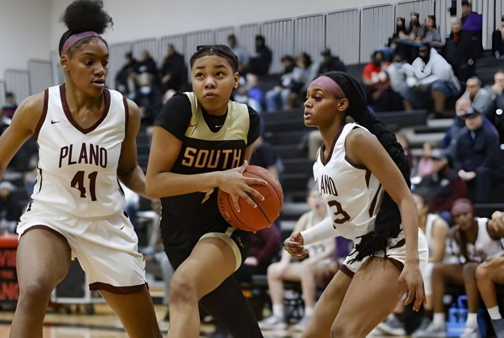 Drei Basketballspielerinnen, eine von der Wellington Heights Secondary School, spielen auf dem Basketballfeld.