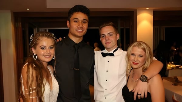 Eine Gruppe von vier Personen in formeller Kleidung posiert zusammen bei einer Veranstaltung der Wellington Point State High School.