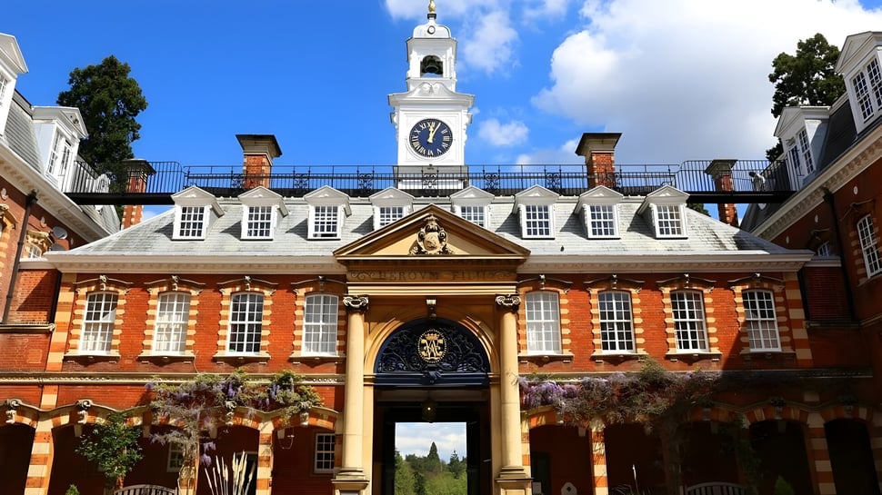 Das Backsteingebäude mit Uhrenturm der Wellington School steht vor grünem Gelände unter blauem Himmel.
