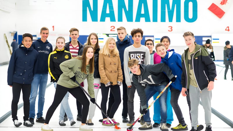 Schüler der Wellington Secondary School stehen gemeinsam vor dem großen Nanaimo Schriftzug.