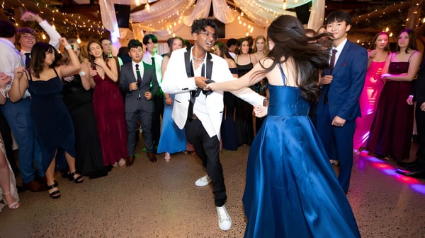 Schüler vom Wentworth College tanzen auf dem festlichen Ball mit bunter Beleuchtung und Dekoration.