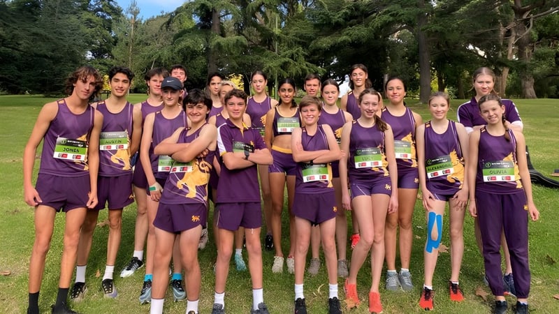 Eine Gruppe junger Athletinnen in lila Uniformen steht auf einer Wiese auf dem Campus von Wesley College.
