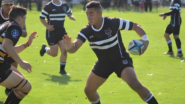 Eine Gruppe von Rugby-Spielern in schwarz-weißen Trikots spielt ein Match auf dem Spielfeld des Wesley College.