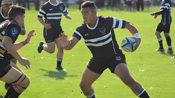 Eine Gruppe von Rugbyspielern in Schwarz-Weiß-Uniformen spielt ein Match auf dem Spielfeld des Wesley College.