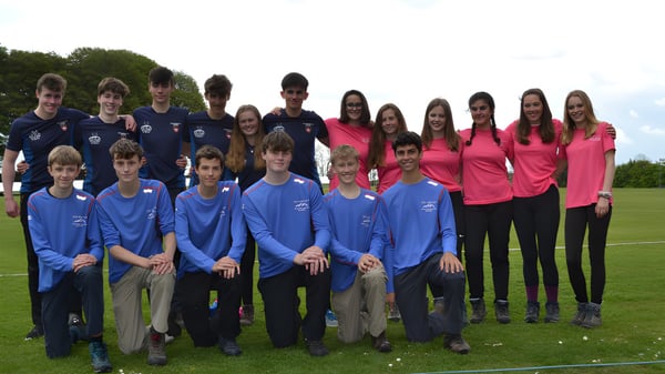 Eine Gruppe von Schülerinnen und Schülern der West Buckland School steht auf einem Grasfeld vor Bäumen.