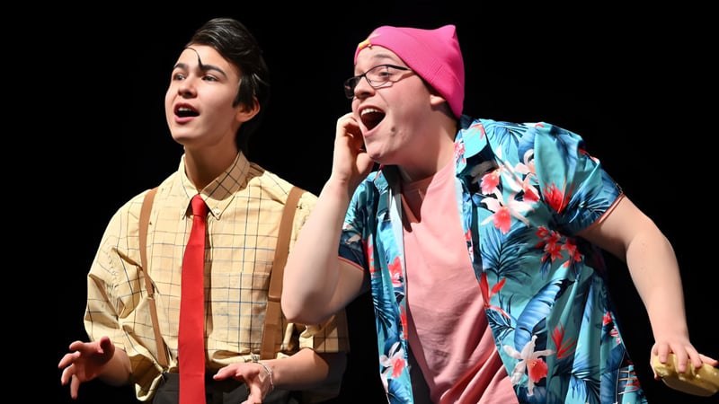 Zwei Darsteller führen eine Bühnenperformance auf der Bühne der West Ferris School auf.