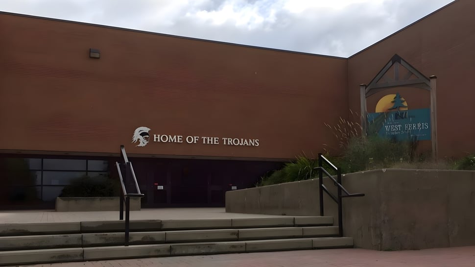 Das braune Gebäude mit der Aufschrift Home of the Trojans auf dem Campus der West Ferris School.