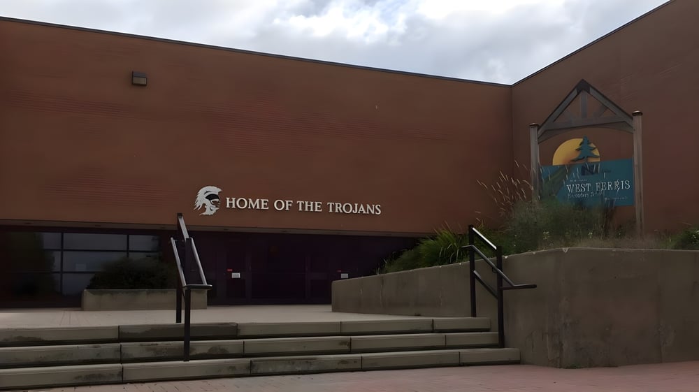 Das braune Gebäude mit der Aufschrift Home of the Trojans auf dem Campus der West Ferris School.