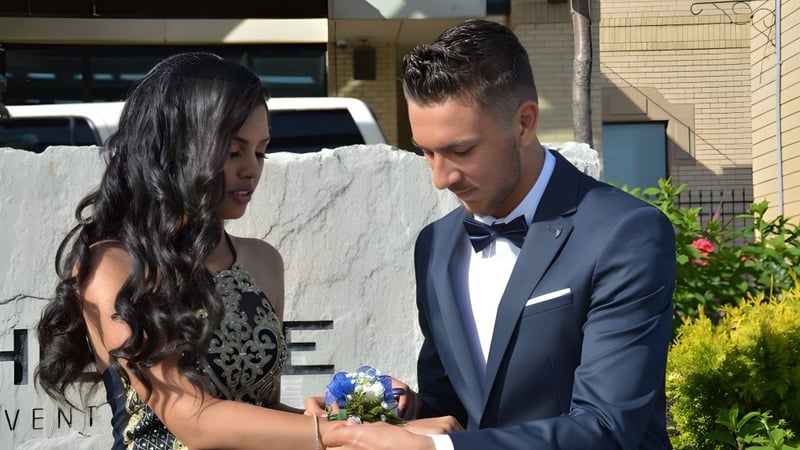 Ein Paar steht in formeller Kleidung vor einem Gebäude des West Humber Collegiate Institute.
