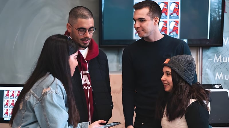 Eine Gruppe von Schülerinnen und Schülern interagiert gemeinsam auf dem Campus der West Vancouver Secondary.