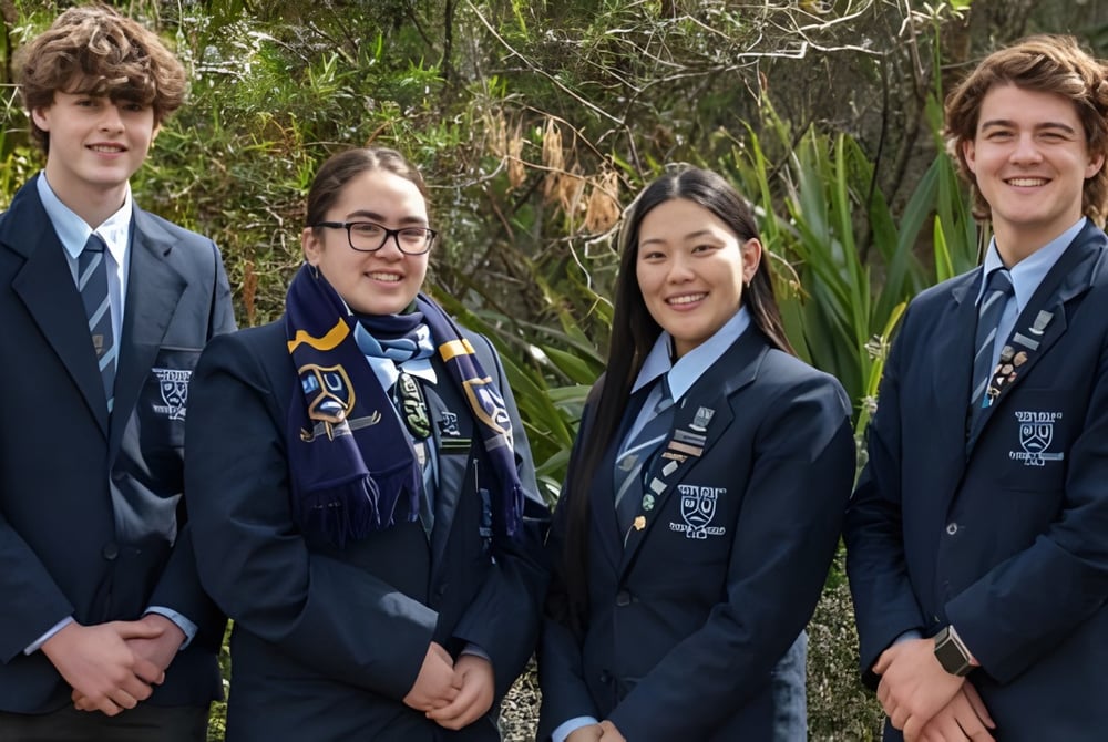 Vier Schülerinnen und Schüler der Western Heights High School stehen gemeinsam im Freien vor Bäumen und Pflanzen.