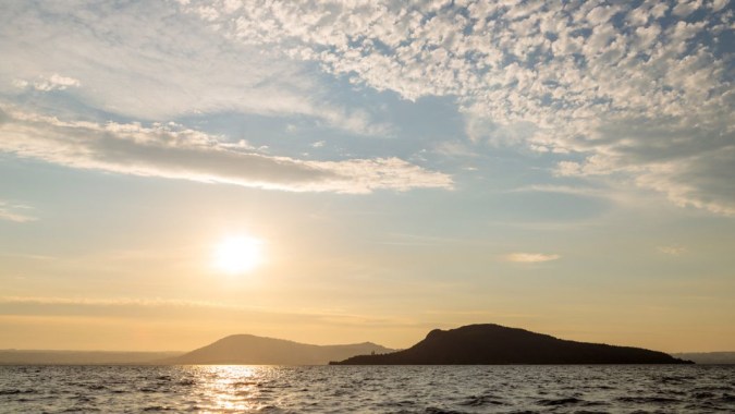 Die Landschaft mit Bergen und Sonnenuntergang ist hinter dem Gelände der Western Heights High School zu sehen.