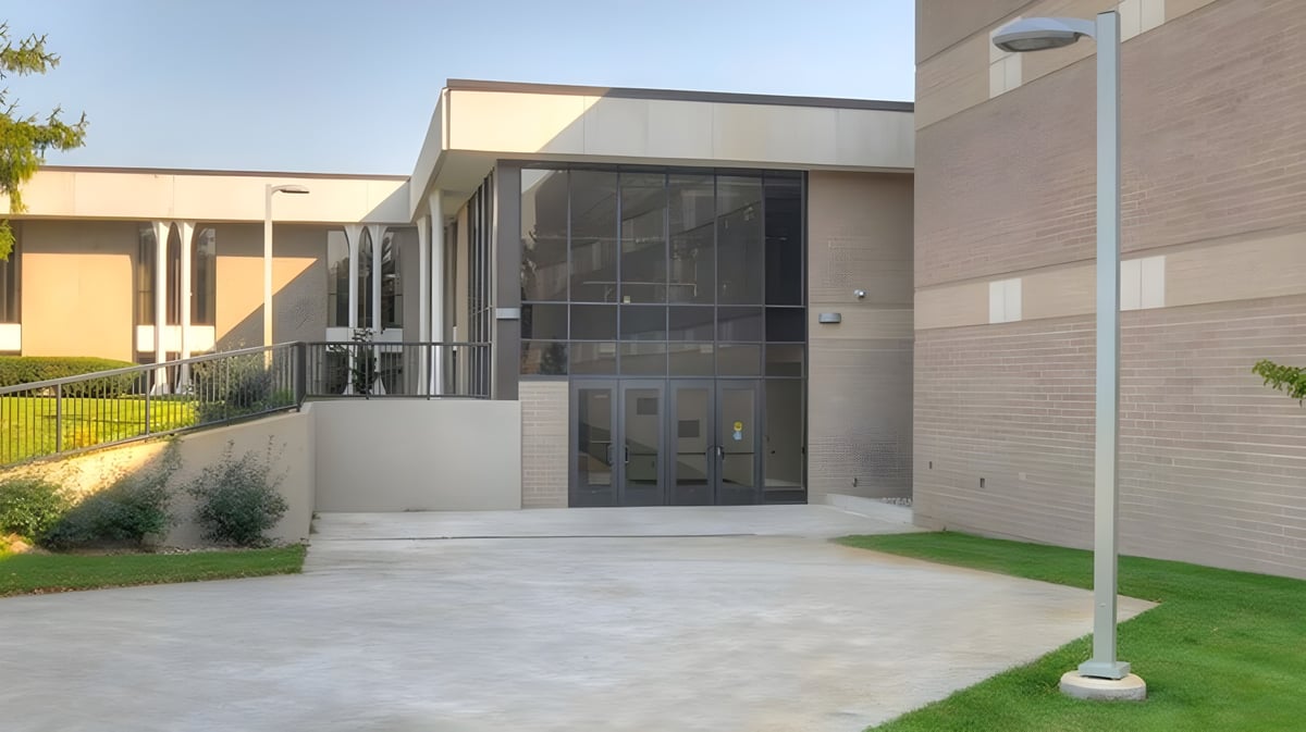 Das moderne Gebäude der Western Michigan Christian School mit Glasfront und einem gepflasterten Eingangsbereich bei klarem Himmel.