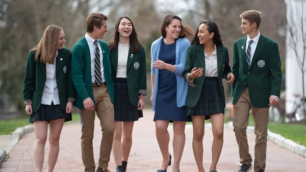 Schüler der Western Reserve Academy gehen gemeinsam auf einem von Bäumen umgebenen Weg.