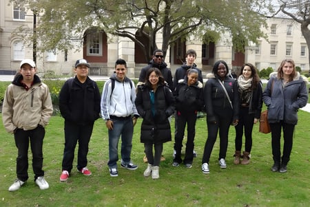Eine Gruppe von Schülerinnen und Schülern steht vor einem historischen Gebäude auf dem Campus der Western Technical-Commercial School.