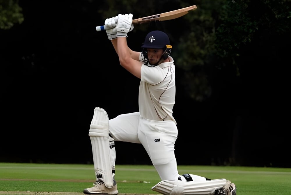 Ein Cricketspieler in weißer Uniform steht auf dem Spielfeld des Westgate Collegiate & Vocational Institute und bereitet sich vor zu schlagen.