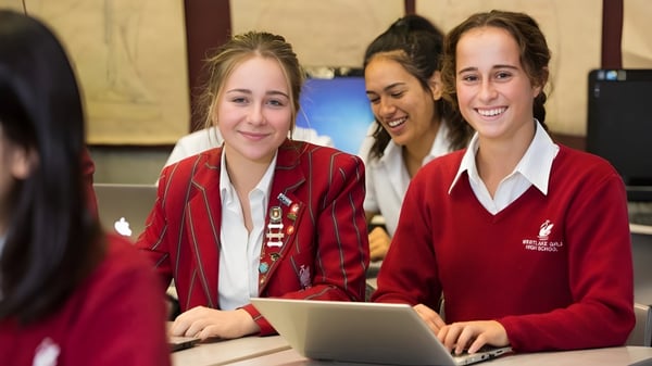 Zwei Schülerinnen der Westlake Girls High School nutzen einen Laptop im Klassenraum mit Kunstwerken an den Wänden.