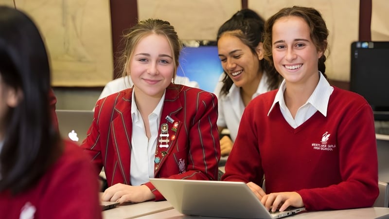 Zwei Schülerinnen der Westlake Girls High School nutzen einen Laptop im Klassenraum mit Kunstwerken an den Wänden.
