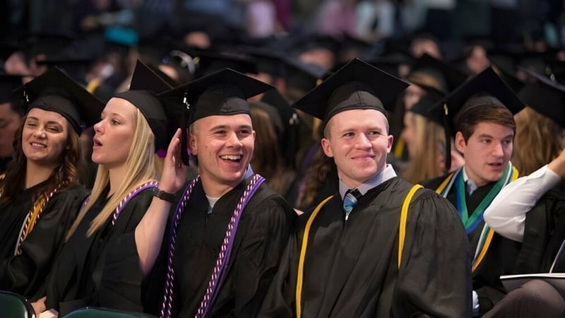 Eine große Gruppe von Absolventinnen und Absolventen der Westminster Secondary School in akademischer Kleidung bei einer Abschlussfeier.