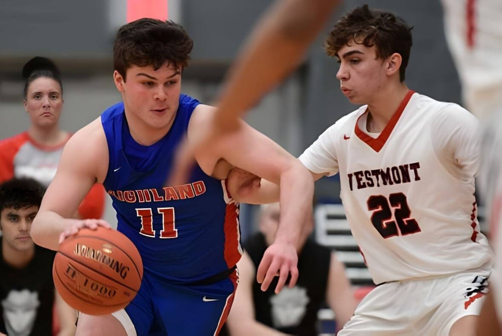 Zwei Schüler der Westmount High School spielen Basketball gegeneinander auf dem Spielfeld.