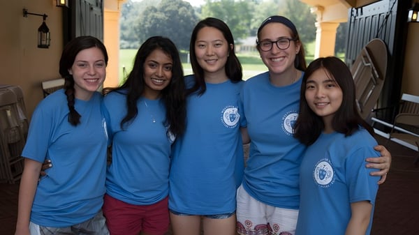 Fünf Schülerinnen der Westover School stehen draußen vor einem Gebäude und Bäumen zusammen und lächeln.