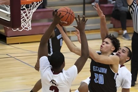 Zwei Basketballspielerinnen und Spieler kämpfen um den Ball auf dem Spielfeld der Westtown School.