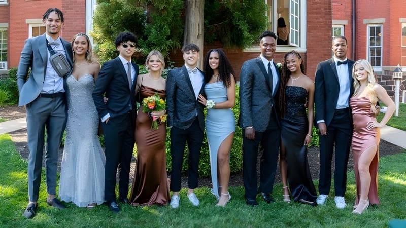 Eine Gruppe von Personen posiert vor einem Backsteingebäude auf dem Campus der Westtown School.