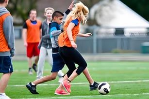 Schüler der Westview Secondary School spielen Fußball auf einem Grasfeld.