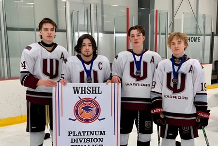 Eine Gruppe junger Hockeyspieler hält im Westwood Collegiate vor einer Eishalle ein Banner der WESHL Platinum Division.