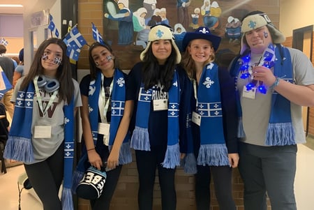 Eine Gruppe Schülerinnen und Schüler der Westwood High School steht in einem Flur vor einer Wand mit einem Wandbild.