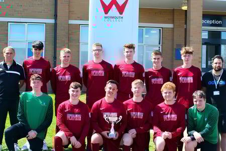 Eine Gruppe von Schülern posiert vor dem Gebäude mit dem Schild des Weymouth College.