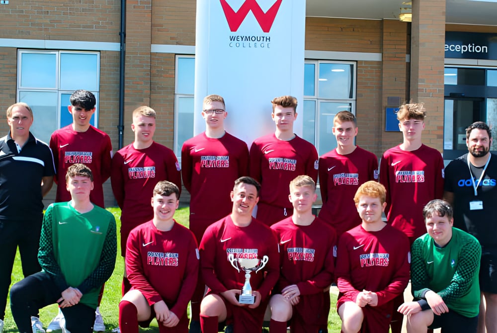 Eine Gruppe von Schülern posiert vor dem Gebäude mit dem Schild des Weymouth College.