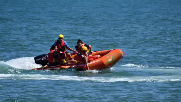 Zwei Schüler vom Whanganui City College steuern ein oranges Schlauchboot auf dem bewegten Ozean.
