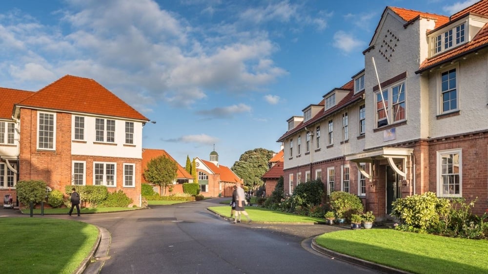 Eine Wohnstraße mit traditionellen Backsteingebäuden und grüner Umgebung auf dem Campus der Whanganui Collegiate School.