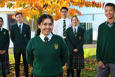 Eine Gruppe von Schülerinnen und Schülern der Whanganui High School steht vor herbstlichem Laub.