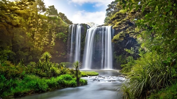 Eine doppelte Wasserfalllandschaft mit einem ruhigen Bach im Vordergrund auf dem Gelände der Whangarei Boys’ High School.