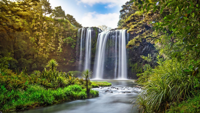 Eine grüne Landschaft mit einem doppelten Wasserfall vor dem Campus der Whangarei Boys’ High School.