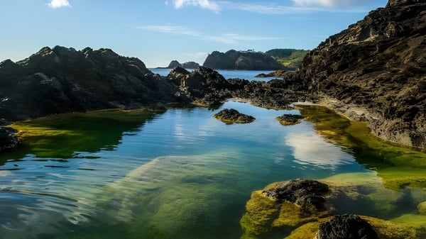 Ein natürlicher Pool mit felsigen Klippen und Inseln, ohne direkten Bezug zur Whangarei Girls High School.