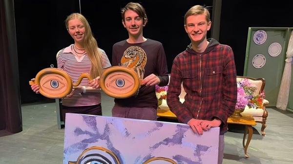 Drei Schülerinnen und Schüler der Whistler Secondary School halten bunte runde Objekte während einer Bühnenperformance.