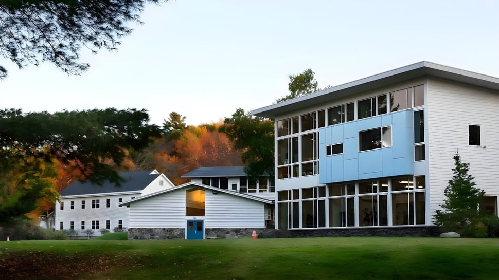Das mehrstöckige Gebäude der White Mountain School ist von Bäumen mit Herbstlaub umgeben.