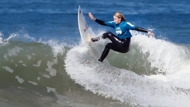 Ein Surfer reitet eine große Welle im Ozean mit klarem Himmel im Hintergrund, aufgenommen beim Whites Hill State College.