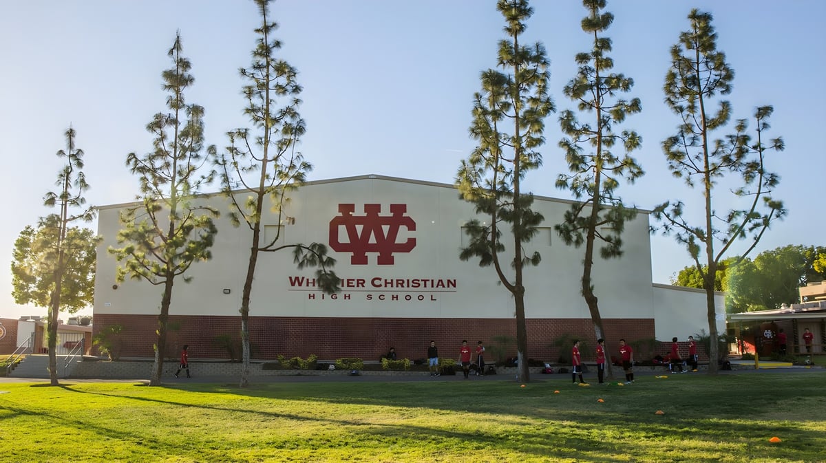 Das Hauptgebäude der Whittier Christian High School ist aus Backstein und steht umgeben von Rasenfläche und Bäumen.